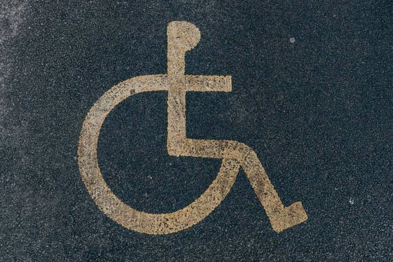 Painted disability icon on asphalt pavement, demonstrating importance of monitoring disability parking