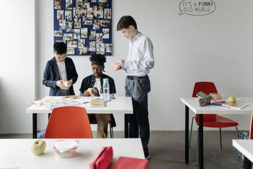 Three school pupils playing in a classroom because of increased school safety with integrated security systems. 